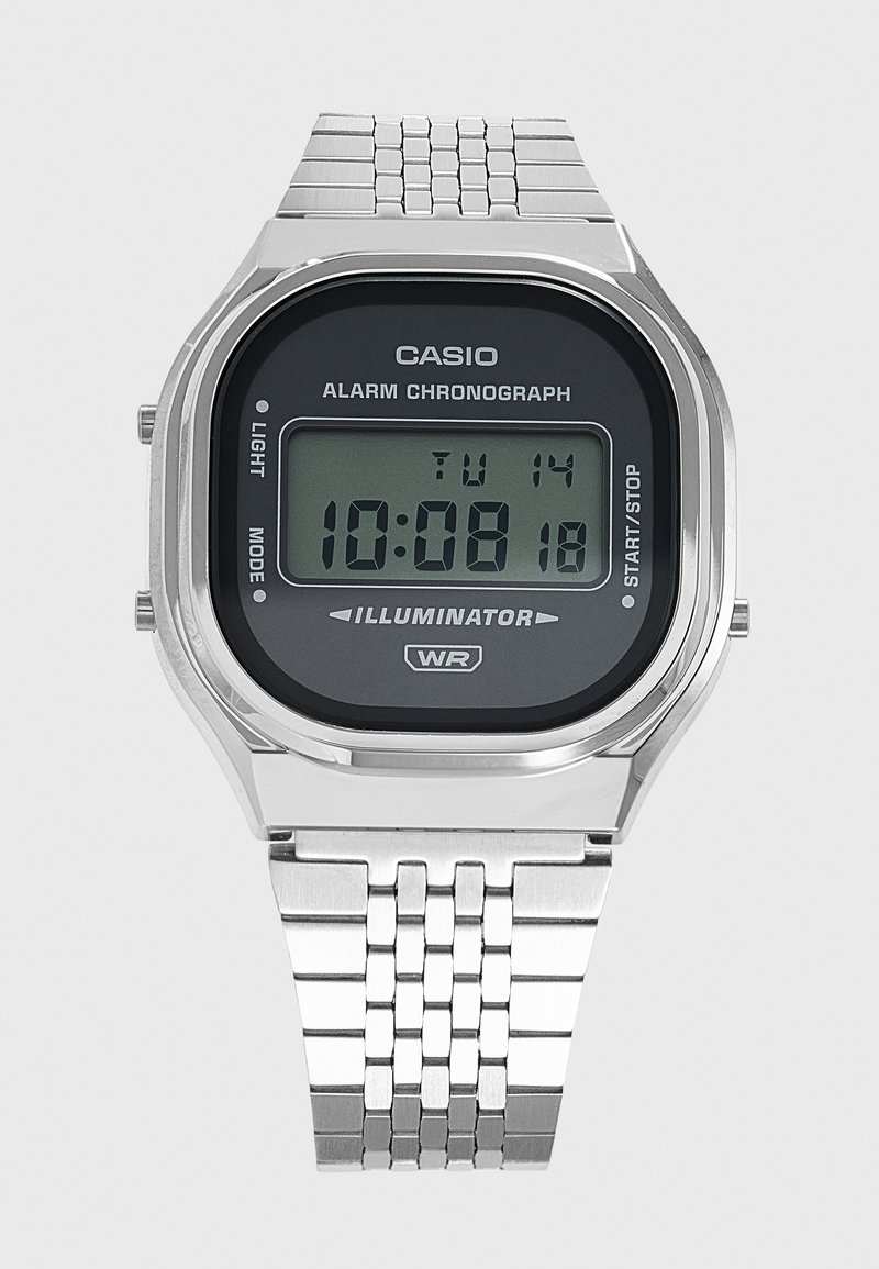 Ψηφιακό ρολόι Casio με ασημένιο μεταλλικό λουράκι, που δείχνει ώρα 10:08:18, ημερομηνία Τρίτη 14, με λειτουργίες ξυπνητηριού, χρονογράφου και φωτισμού.