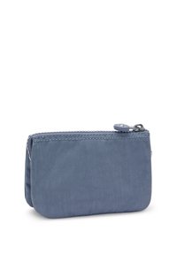 Blå zipplåda gjord av mjukt tyg, med en slät yta och sydda sömmar. Kompakt rektangulär form med en rund dragkedjepärr.