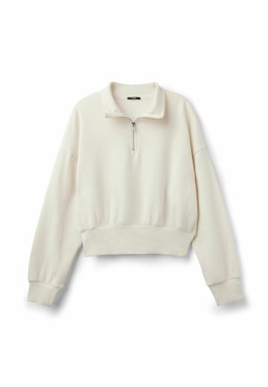 Hellbeige cropped Sweatshirt mit einem Reißverschluss-Halsteckkragen, lockeren Ärmeln sowie gerippten Saum und Bündchen. Weiche, glatte Textur.