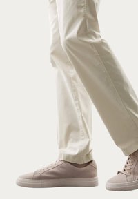 Hellbeige Chinos mit lockerer Passform, kombiniert mit blushfarbenen Wildledersneakern mit runder Spitze und flacher Sohle.