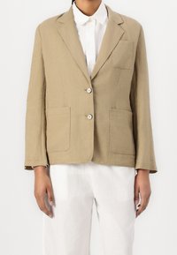 Blazer di lino beige con una tasca sul petto, due tasche frontali e chiusura con bottoni. Caratterizzato da un rever a scollo a V e maniche lunghe.