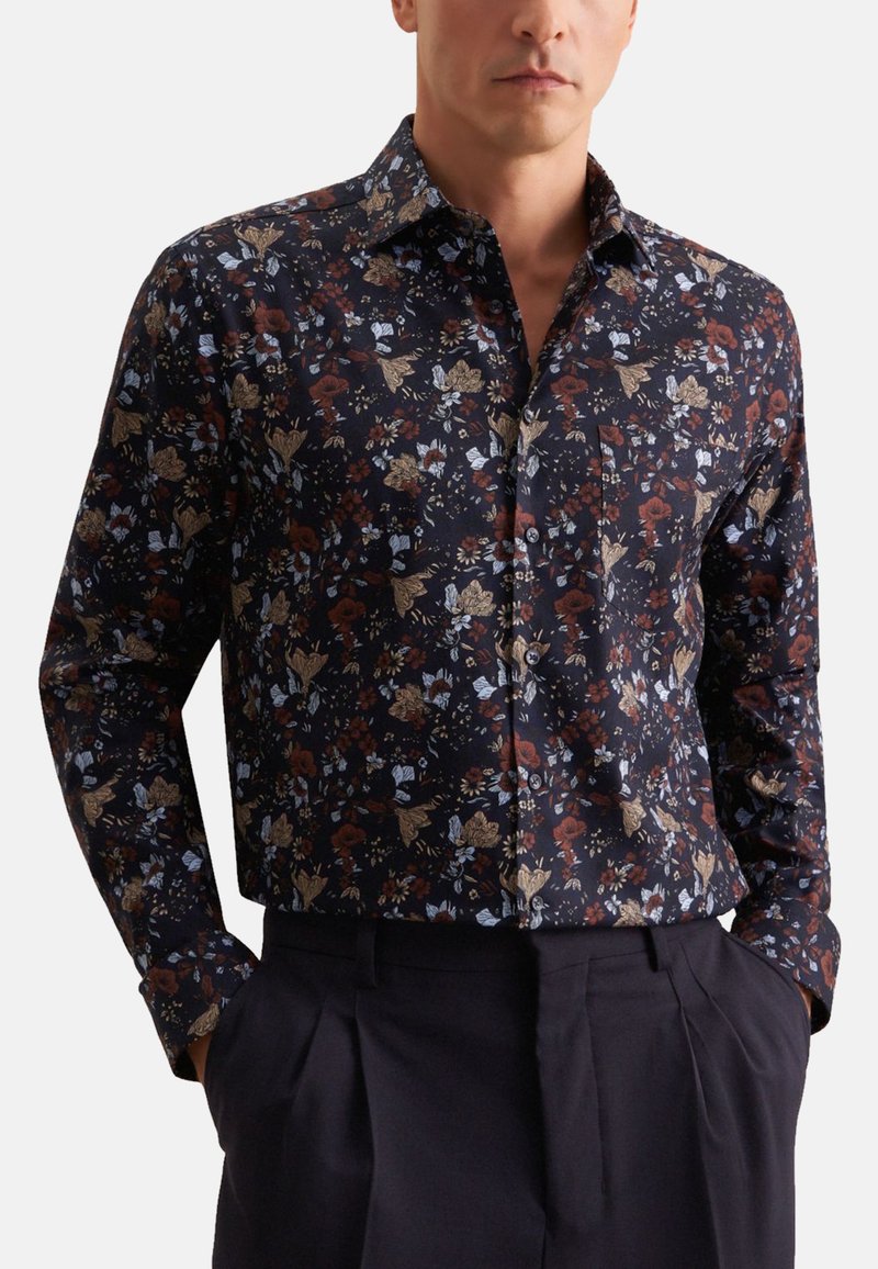 Langærmet skjorte i mørkeblå stof med blomstermønstre i bordeaux, guld og lyseblå. Inkluderer en knap-ned krave og en brystlomme.