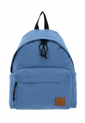 Light blue backpack with black zipper pulls, a front zippered pocket, and a small brown rectangular patch on the lower right corner.
