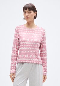 Różowy top z długim rękawem z zimowym wzorem z białymi kwiatami, sercami i zwierzętami. Wykonany z miękkiego materiału, z okrągłym dekoltem.