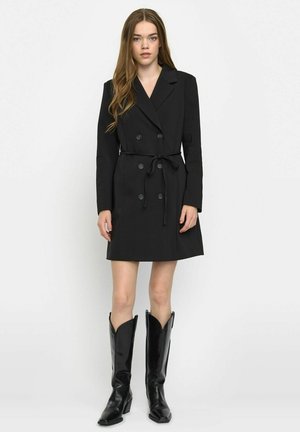 Black double-breasted coat with a tie belt. Features notched lapels, long sleeves, and a knee-length design. Paired with knee-high black boots.