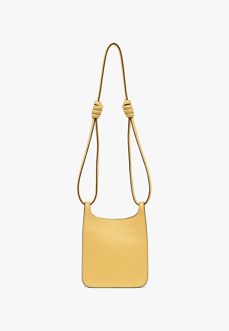 Gelbe Lederhandtasche mit glatter Textur, rechteckiger Form und einem langen, verstellbaren Tragegurt mit Knoten-Details.