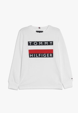 Weißes Langarm-T-Shirt mit einem schwarzen rechteckigen Grafikelement, auf dem die Worte "TOMMY" und "HILFIGER" stehen, sowie einem roten horizontalen Streifen darunter.