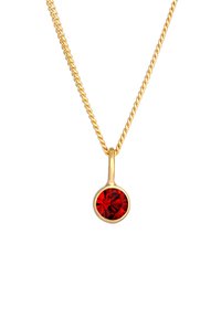 Collana in oro con pendente a forma di cristallo rosso rotondo, con una montatura metallica liscia e un design semplice.
