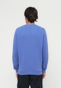 Blå genser med rund hals og lange ermer, laget av mykt stoff, med ribbestrikkede mansjetter og hem, minimalistisk design, og uten synlige logoer.