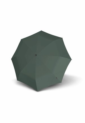 Dark green eight-panel umbrella open and upright casting a shadow on a white surface.