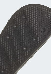 Schwarze Gummisohle mit einem strukturierten Diamantmuster, erhöhten runden Griffen für Traktion und einer glatten Kante.