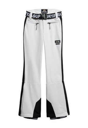Białe spodnie narciarskie z czarnymi panelami po bokach, zapinanymi na zamek kieszeniami z przodu, rozszerzanymi nogawkami oraz czarno-białym regulowanym paskiem z logo "Superdry".