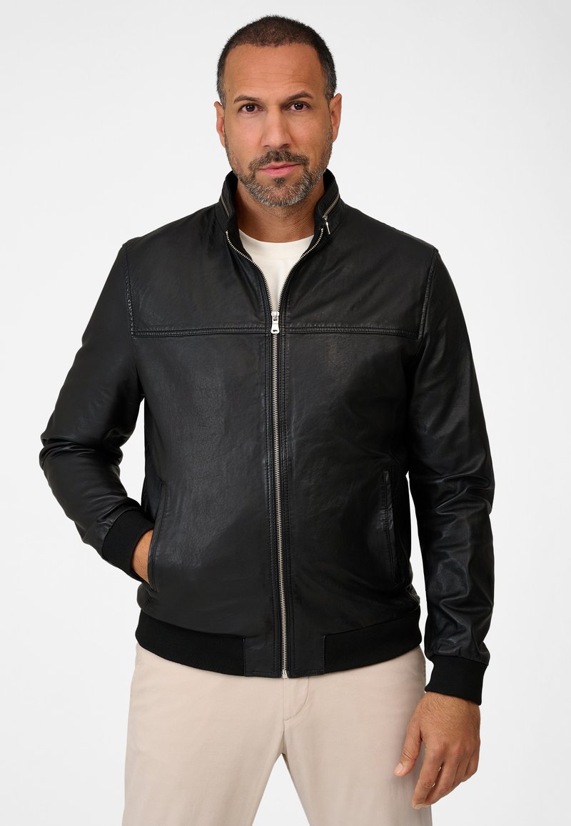 Black leather jacket with a stand-up collar, front zip closure, and ribbed cuffs. Features a smooth texture and stitched detailing across the chest.