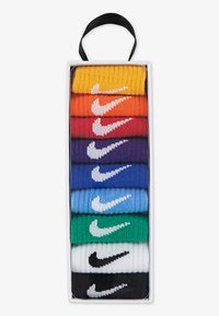 Deväť párov farebných ponožiek v obdĺžnikovom boxe, z ktorých každé má výraznú bielu Nike šípku. Farby zahŕňajú žltú, oranžovú, červenú, purpurovú, modrú, zelenú, bielu a čiernu.