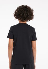 Černé bavlněné tričko s krátkým rukávem a kulatým výstřihem, s hladkou texturou a jednoduchým designem, pohled ze zad.