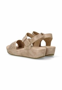 Sandalias beige con un diseño texturizado y perforado en la puntera. Cuenta con dos correas ajustables y una suela de cuña de 3.8 centímetros. Material suave similar al ante.