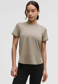 Beige, short-sleeve t-shirt made of soft, lightweight fabric. Featuring a round neck and relaxed fit, with a smooth texture and no visible patterns.