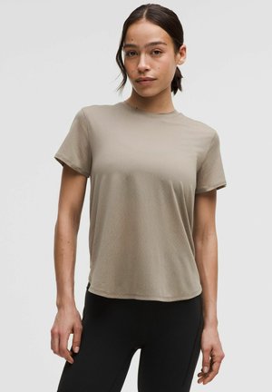 Beige, short-sleeve t-shirt made of soft, lightweight fabric. Featuring a round neck and relaxed fit, with a smooth texture and no visible patterns.