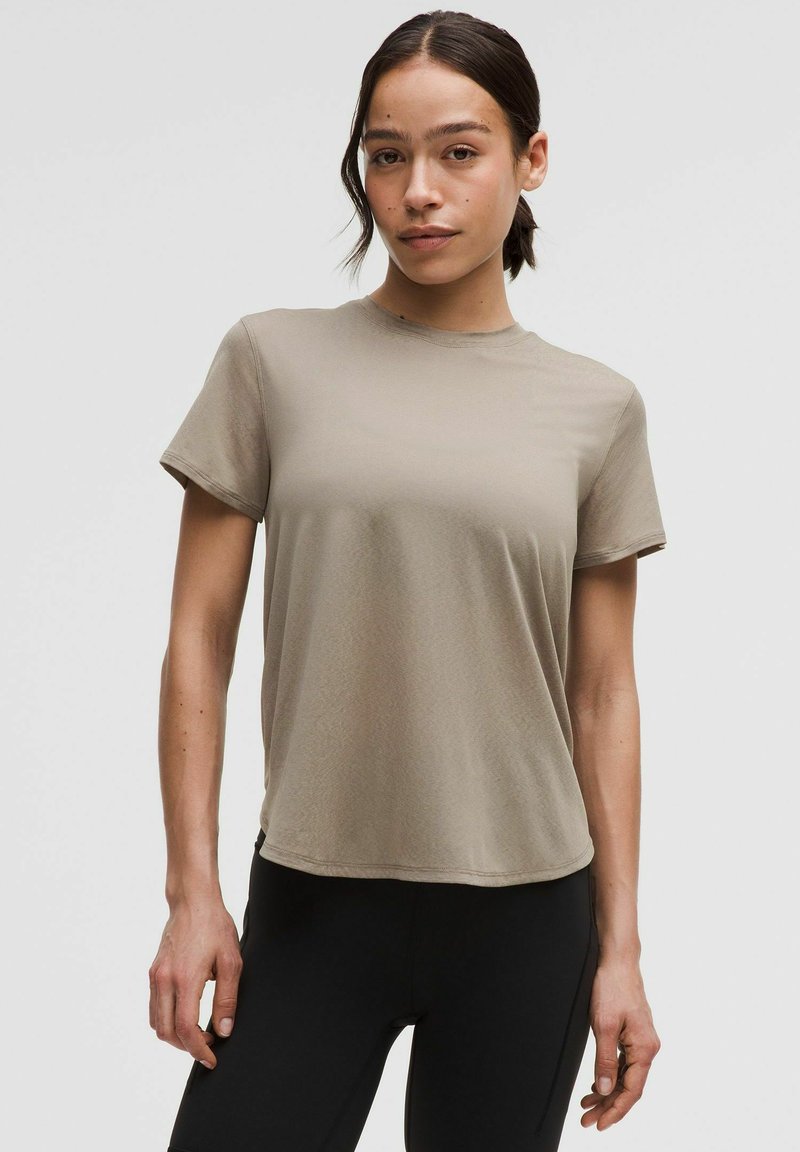 Beige, short-sleeve t-shirt made of soft, lightweight fabric. Featuring a round neck and relaxed fit, with a smooth texture and no visible patterns.