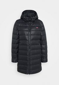 Svart quiltad lång pufferjacka med huva, framfickor med dragkedja och en liten röd Levi's-logotyp på vänster bröst.