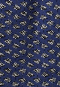 Tessuto blu con un motivo ripetuto di fiori bianchi con contorni neri, disposto in colonne verticali su una superficie texturizzata.