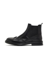 Botas Chelsea de cuero negro con acabado suave, detalles de perforaciones tipo brogue, paneles elásticos en los laterales y puntera redondeada. Suela plana.