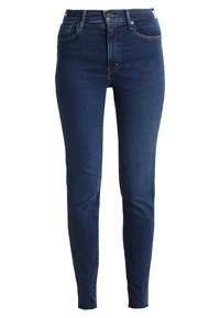Eng-Jeans aus dunkelblauem Denim, hoch geschnitten mit einer glatten Oberfläche. Sie verfügen über fünf Taschen und minimale Nähte für einen klaren Look.