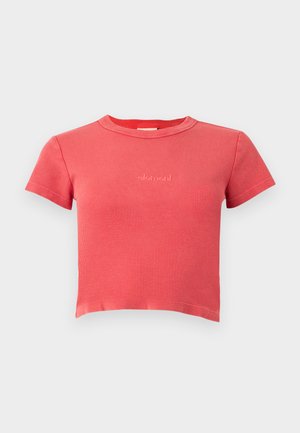 Koralfarvet ribbet kortærmet cropped t-shirt med rund halsudskæring og lille broderet "element"-logo på brystet, vist på ensfarvet baggrund.