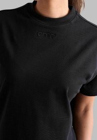 Sort bomulds T-shirt med rund hals og korte ærmer. Tekstureret stof med et subtilt broderet logo på brystet.