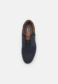 Baskets bleu marine avec un dessus en maille texturée, langue en cuir brun et accents orange. Elles disposent de lacets et d'une semelle intérieure rembourrée. Taille 42.