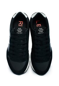 Sneakers neri realizzati in un mix di pelle scamosciata e materiali sintetici, punta rotonda, lacci flat e etichetta interna stampata con testo.