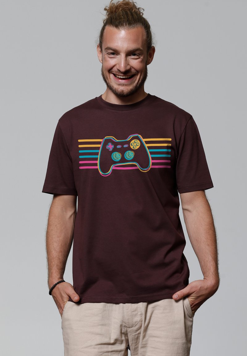 Bruine katoenen T-shirt met een zwart spelcontroller graphic en kleurrijke gestreepte accenten in roze, blauw en geel. Korte mouwen.