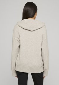 Felpa con cappuccio grigio chiaro dalla vestibilità comoda, polsini e fondo a costine. Dotata di cappuccio con coulisse e tessuto lavorato a maglia morbido. Vista posteriore mostrata.