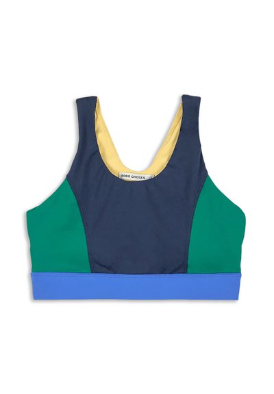 Färgbockad sport-bh med marinblå framdel, gröna sidopaneler, blå nederkant och gul innervadd, liggande platt på vit bakgrund.