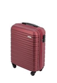 Valise rigide rouge avec un design rainuré, roues noires, poignée supérieure et fermeture éclair. Fabriquée à partir de matériaux durables pour une efficacité lors des voyages.