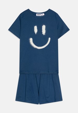 Kék pamut rövid ujjú póló és rövidnadrág szett, fehér festékszórós mosolygós arc mintával az elején. Kényelmes szabás, puha tapintás.