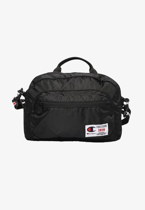 Schwarze Champion Schultertasche mit Frontreißverschlusstasche, oberem Griff, verstellbarem Riemen und weißem Logo-Patch mit rotem und blauem Text.