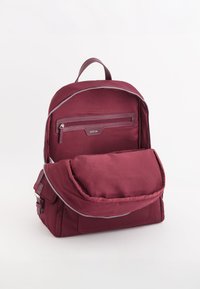Mochila de tela burdeos con cremallera en la parte superior, bolsillo frontal con cremallera y correas ajustables. Textura suave, diseño elegante y hardware mínimo.
