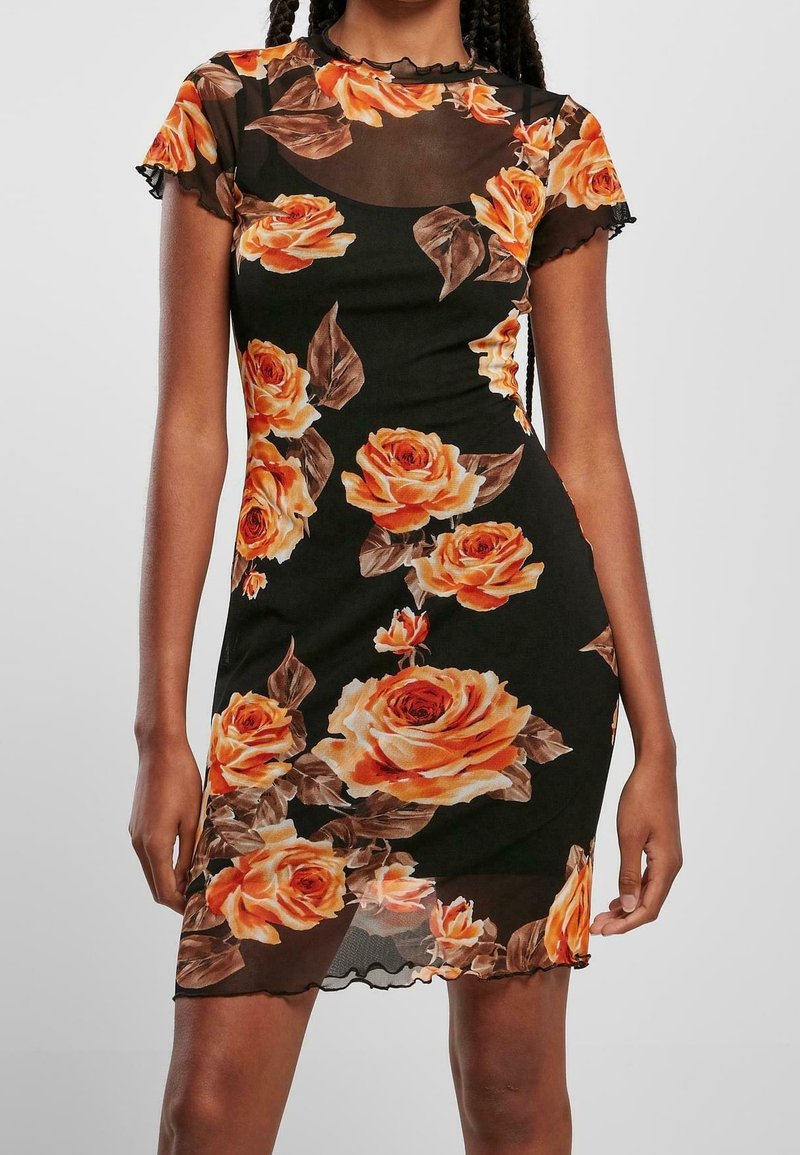 Robe noire ajustée avec haut et manches en tulle transparent, décorée d'une grande rose orange et d'un imprimé floral aux feuilles marron.