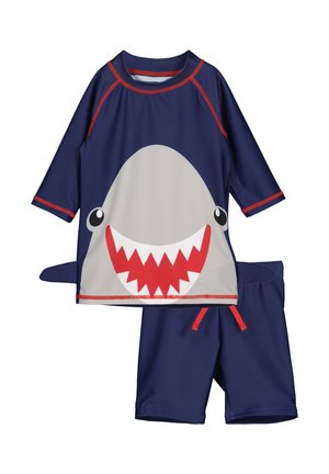 Navy-Kinder-Badeanzugsset mit rotem Besatz, mit großem Hai-Gesicht auf dem Shirt und einer Flosse an der Seite, kombiniert mit passenden Navy-Shorts.