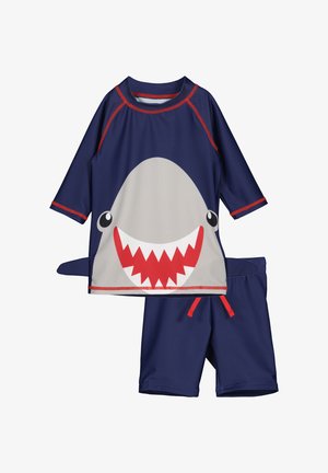 Navy-Kinder-Badeanzugsset mit rotem Besatz, mit großem Hai-Gesicht auf dem Shirt und einer Flosse an der Seite, kombiniert mit passenden Navy-Shorts.