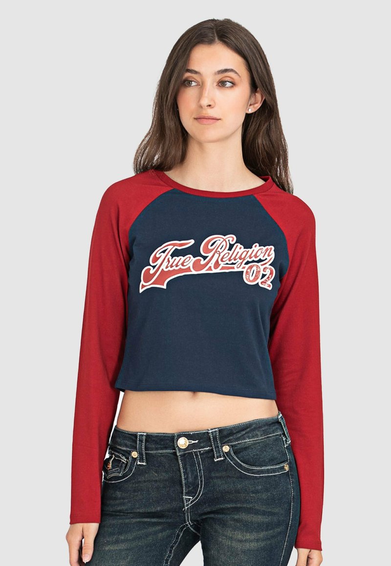 Langärmliges Crop-Top mit navyfarbenem Körper und roten Raglanärmeln. Verfügt über das weiße "True Religion"-Logo und "02" in kontrastierendes Design. Aus Baumwollmaterial.