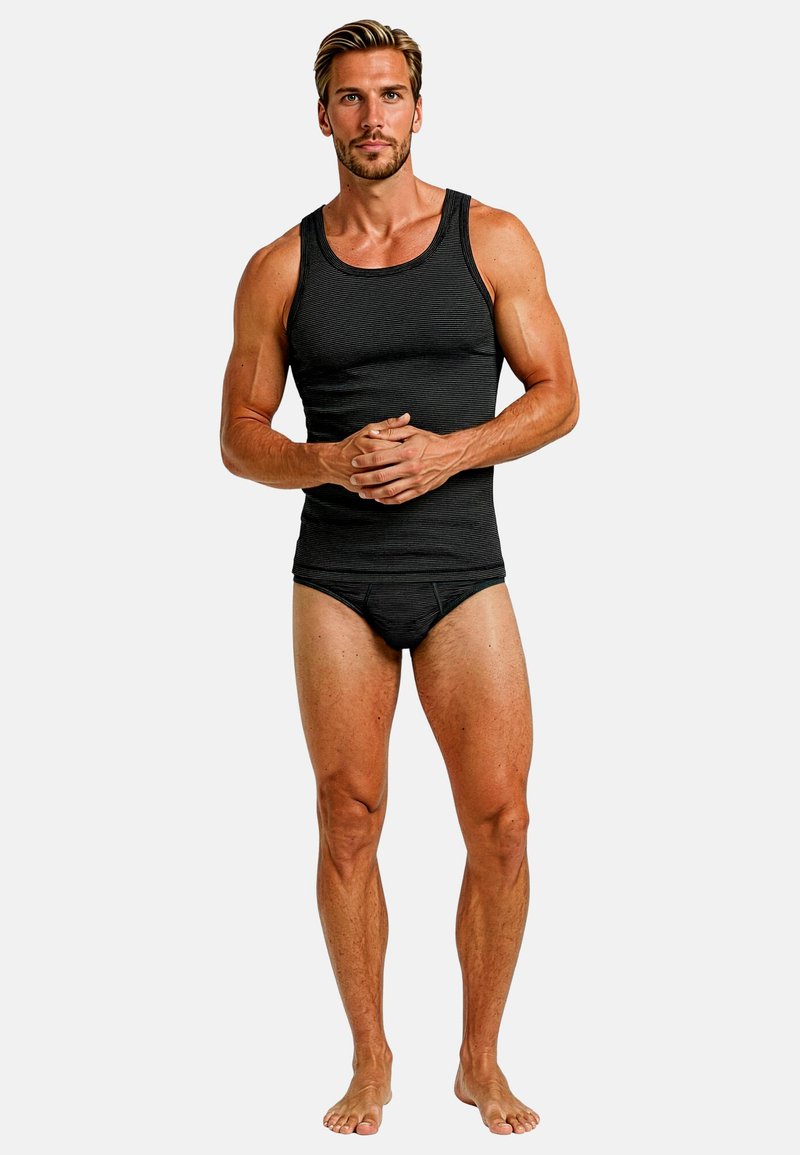 Zwart tanktop met horizontale strepen, gedragen met bijpassende slips. De stof lijkt glad en aansluitend, wat de lichaamsvorm benadrukt.