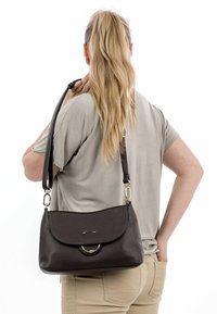 Borsa a tracolla in pelle marrone scuro con una chiusura arrotondata, hardware in metallo e una tracolla rimovibile, presentata su uno sfondo semplice.