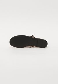 Sandalo piatto con tomaia decorata in multicolori, suola in gomma nera e design della fascia semplice per una vestibilità sicura.