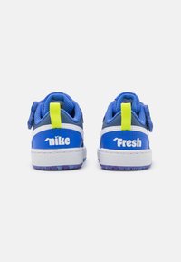 Niebieskie sneakersy Nike z teksturowaną siateczkową cholewką, białą i fioletową podeszwą, dwoma rzepami oraz logo na piętach.