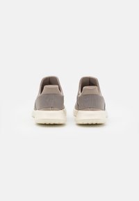Šedé boty na slip-on s texturovaným svrškem a bílou gumovou podrážkou. Mají hladký design a polstrovaný límec pro pohodlí.