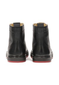 Černé kožené kotníkové boty se hladkým povrchem, kulatou špičkou a kontrastní červenou gumovou podešví. Disponují minimalistickým designem a poutkem na nazouvání.