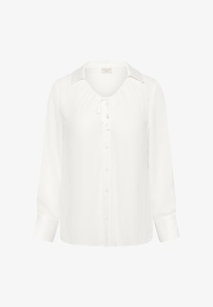 Fehér, hosszú ujjú blúz gallérral, elől gombokkal és a nyakkivágásnál egy kis masnival.