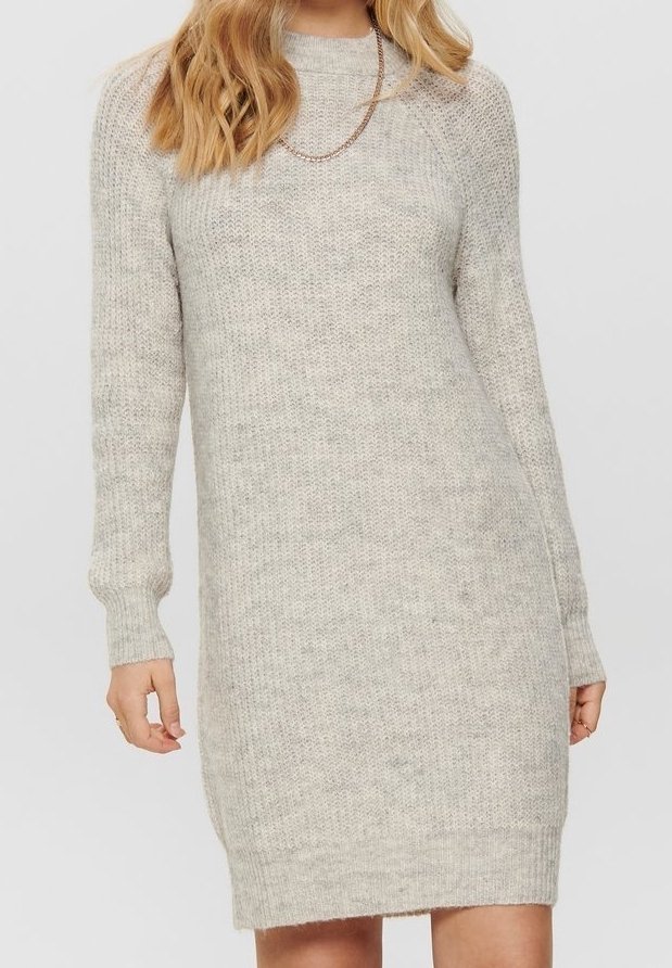 Femme portant une robe-pull tricotée gris clair à manches longues, avec un col rond et un simple collier chaîne.
